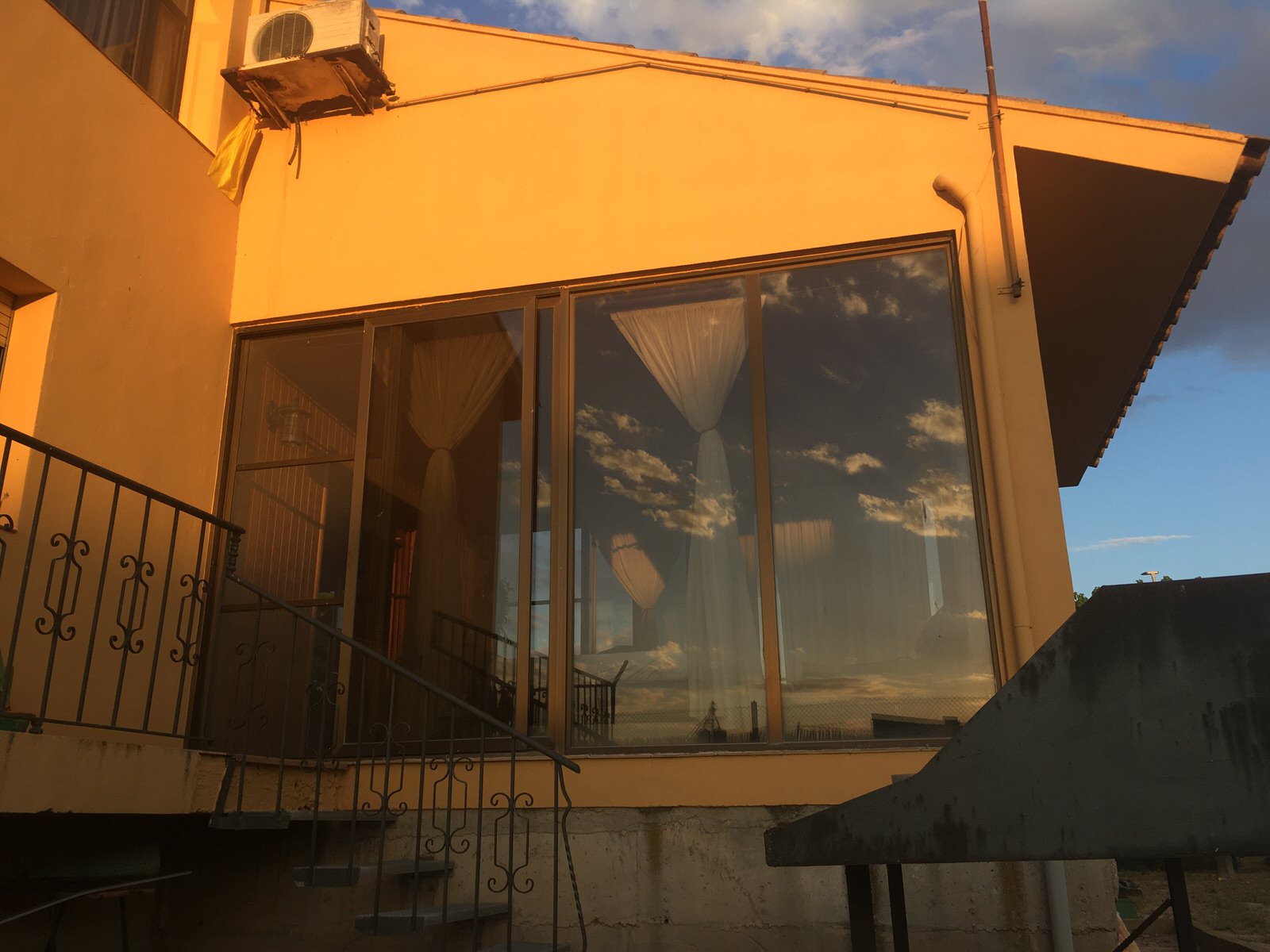Ventana de un proche donde se refleja el cielo azúl del verano en Preixana, Cataluña.