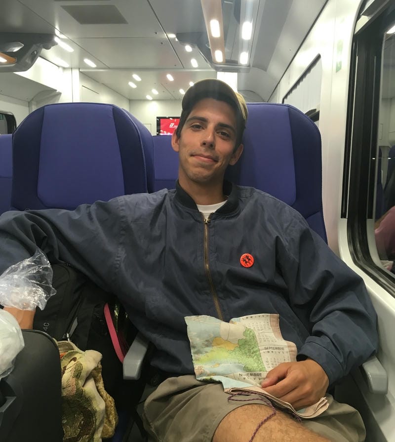 This guy called Pablo is in a train, smiling at the camera (becasue Maddalena took the picture) and he have a cap he found in some village, and his always present napkin.